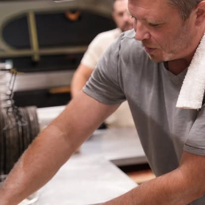 Founder Jon Dempster stretching pizza dough